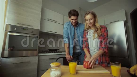 年轻的女士在厨房为她的男人做早餐视频的预览图