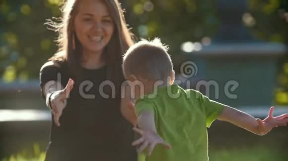 妈妈和小儿子在夏天的公园里玩日落慢动作视频的预览图