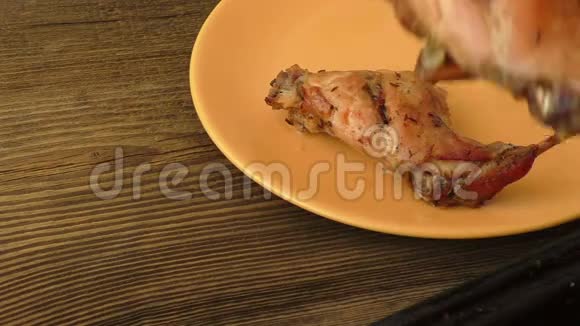 在深色木质背景的盘子上烤兔子腿视频的预览图