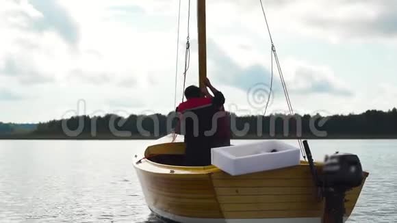 师傅和他的助手在河上的木帆船上工作视频的预览图