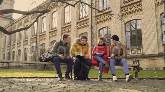 四个学生坐在公园的长凳上视频的预览图