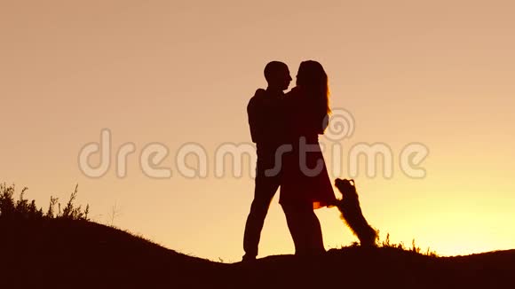 情侣恋爱吻颈漫步夕阳上剪影自然慢动作视频男人和女人爱走的剪影视频的预览图