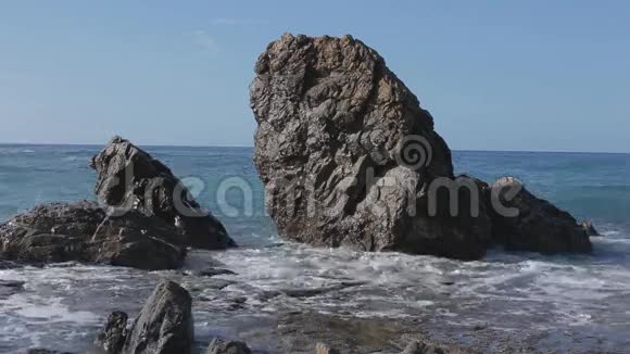 海浪拍打在大石头上晴天视频的预览图