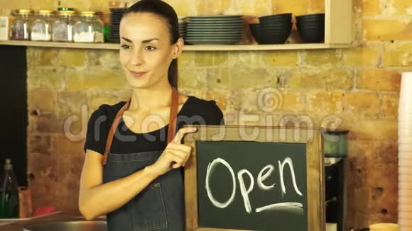 一个咖啡店的工人拿着一个开放的标志视频的预览图