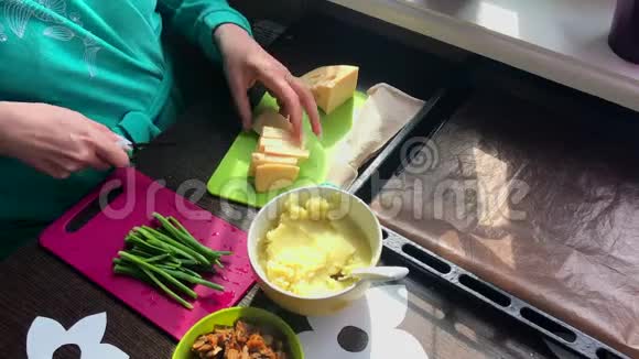 女人在切割板上切奶酪接下来的盘子是葱土豆泥和炸蘑菇视频的预览图