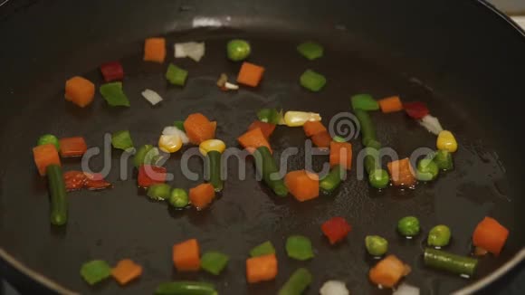 新鲜蔬菜用油煎锅慢动作特写冷冻蔬菜混合在煎锅上铺设蔬菜视频的预览图