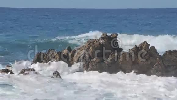 海浪拍打在大石头上晴天视频的预览图