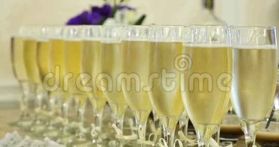 宴会或庆典期间优雅的酒杯和香槟酒排在餐桌上视频的预览图