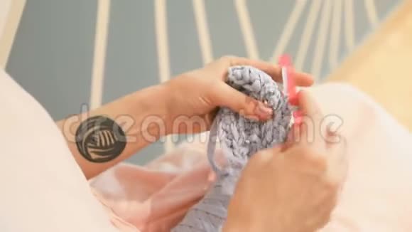 编织的手制造了爱好年轻女子的手与拼贴时髦纹身工作钩针编织柔和的日光视频视频的预览图