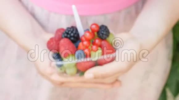 把女人手里拿着浆果和水果混合在一起视频的预览图