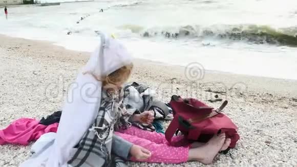 一个小女孩坐在海滨夏季视频的预览图