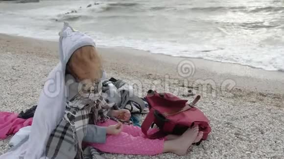一个小女孩坐在海滨夏季视频的预览图