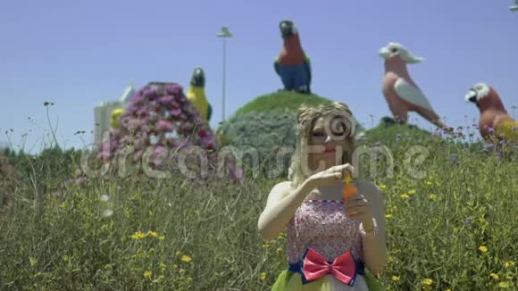 年轻的金发女人在花园里吹肥皂泡漂亮的梦想可爱的女孩穿着滑稽的蕾丝礼服放松视频的预览图