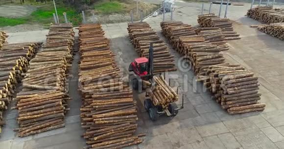 一家木工厂的红色卡车机械手卸下原木工作设备视频的预览图