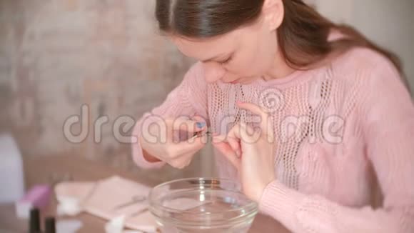 女人用尼珀切角质层自己修指甲手术工具放在桌子上视频的预览图