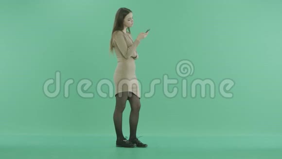 一个女孩站着手里拿着手机发短信视频的预览图