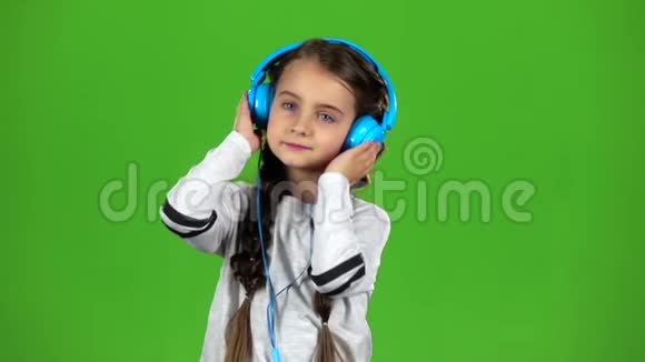 耳机里的孩子在听音乐绿色屏幕慢动作视频的预览图