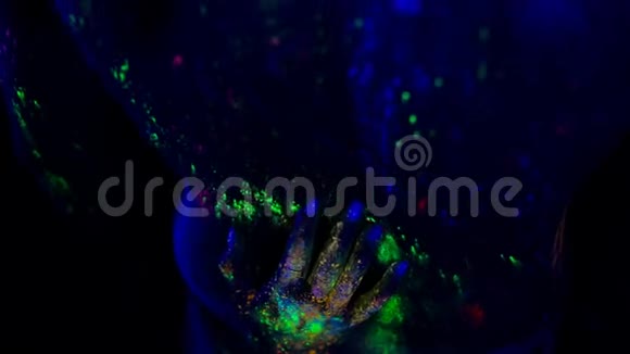 女人的手在紫外线下在男人的背上擦擦视频的预览图