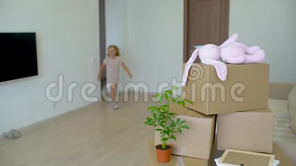 年轻幸福的家庭搬到新公寓两个小女孩和父母一起跑进新家的背景纸板视频的预览图