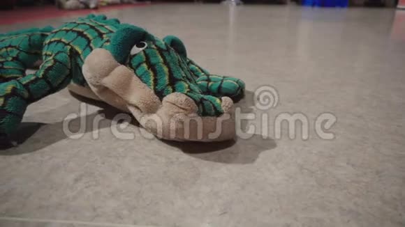 玩具绿鳄鱼躺在地板上视频的预览图