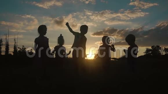 夕阳西下五个小朋友在田野里嬉戏跳舞的剪影视频的预览图