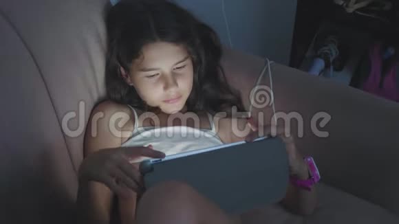 小女孩晚上用平板电脑女孩青少年在网上玩游戏社交媒体女孩和生活方式平板电脑视频的预览图