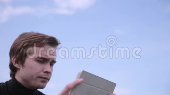 年轻人带着平板电脑坐在公园里聊天冲浪学习海滩上的天空视频的预览图