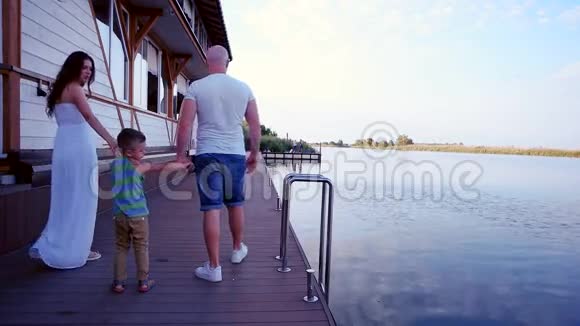 幸福的一家人在船上父母带着一个孩子在河上避暑爸爸妈妈和他的儿子一起度过时光视频的预览图