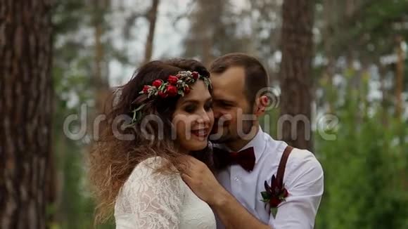 一对迷人的夫妇在夏天的森林里拥抱在一起概念波西米亚婚礼视频的预览图