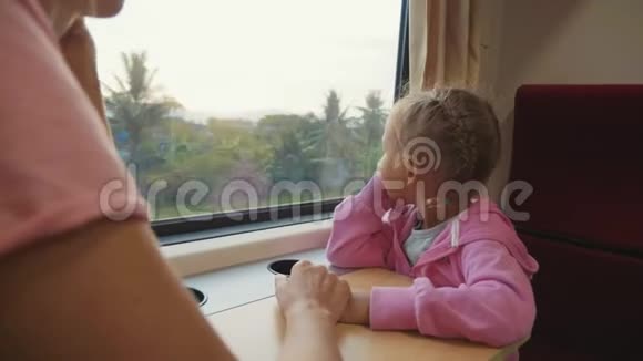 一家人在亚洲的火车旅行中消磨时间寻找窗口交谈视频的预览图