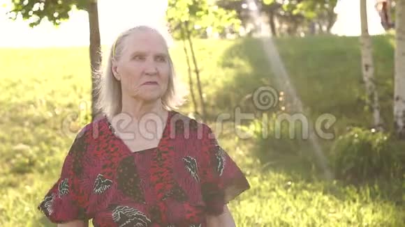 肖像祖母在公园的草地背景视频的预览图
