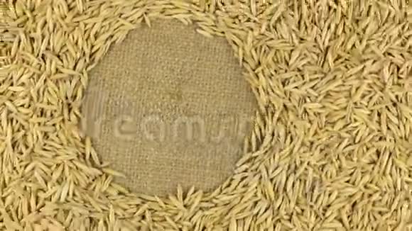 燕麦颗粒在麻布上旋转为你的文字留出空间视频的预览图