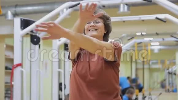 老年妇女伸展身体在健身室做运动健康体操活跃的老年人视频的预览图