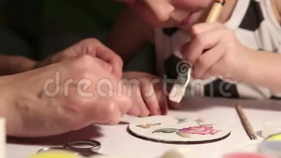 男孩在母亲的帮助下用画笔创作他的艺术作品视频的预览图