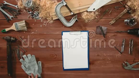 俯视图工匠双手拿着笔和夹纸板放在桌上复印空间视频的预览图