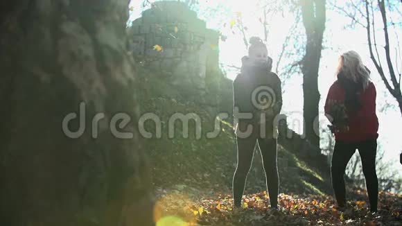 两个女人用慢镜头把树叶抛向空中视频的预览图
