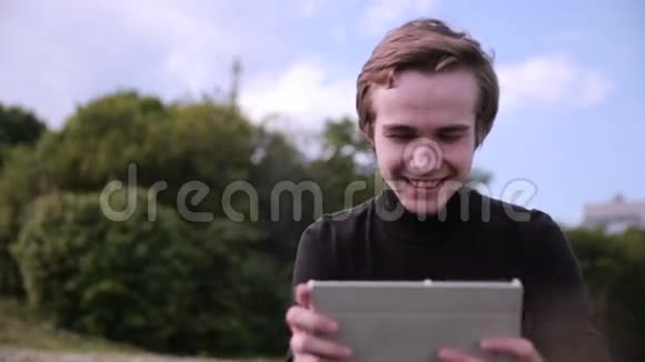 年轻人带着平板电脑在户外聊天冲浪学习看上去很开心视频的预览图