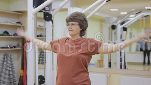 老年妇女伸展身体在健身室做理疗健康体操活跃的老年人视频的预览图