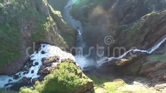 强大的瀑布流入小河在令人叹为观止的石山景观顶部4k空中无人机视图视频的预览图