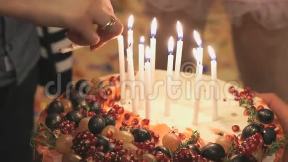 人们的手在结婚蛋糕上点燃蜡烛视频的预览图