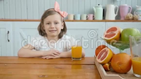 一个在厨房早晨喝新鲜果汁的漂亮女孩视频的预览图