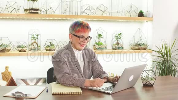 自信快乐的女商人坐着笔记本电脑视频的预览图