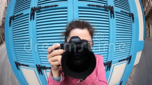 有趣的年轻女摄影师带相机鱼眼视频的预览图