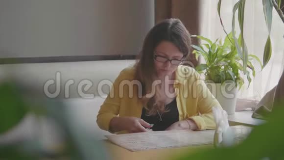 这个女孩正在咖啡馆的慢动作视频中学习菜单等待食物快餐的女孩朋友的陪伴视频的预览图
