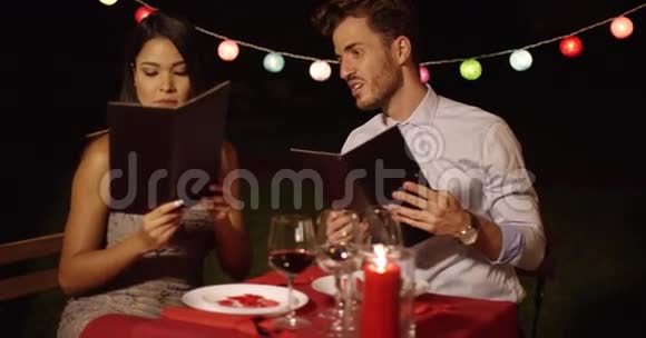 爱的年轻夫妇从菜单上选择食物视频的预览图