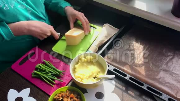 女人在切割板上切奶酪接下来的盘子是葱土豆泥和炸蘑菇视频的预览图