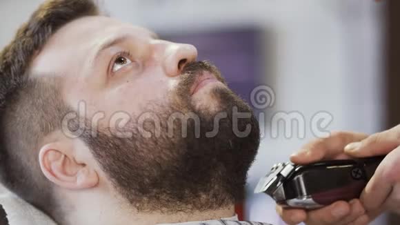 理发店的理发师给顾客剪胡子视频的预览图