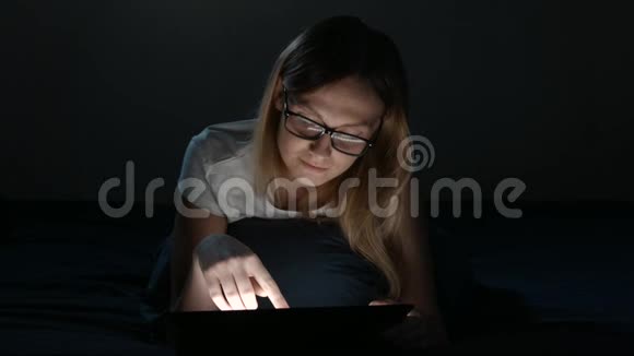 可爱的女孩在睡觉前使用数字平板电脑视频的预览图