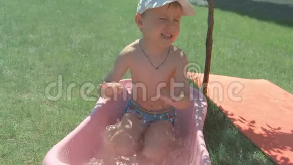 快乐有趣的宝宝笑着拿着玩具车在浴缸里视频的预览图