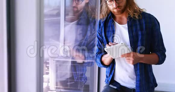 男性高管在窗口附近使用数码平板电脑视频的预览图